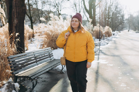Happy 30s woman talking on the phone and looking happy outdoors. Urban lifestyle concept. Winter...