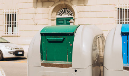 Public trash on the side of the road. Green and blue wheeled recycling rubbish bins beside the road for rubbish collection outdoors. Ecology conceptの写真素材