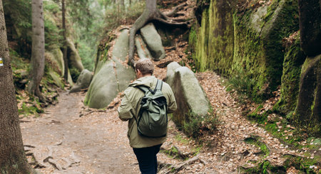 Young 30s man hiking in nature. Travel, adventure. Concept of an active lifestyle. High quality photo. Back view. Fall autumn hiker man outdoor at nature forestの写真素材