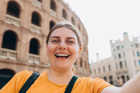 Beautiful 30s female walking in Valencia. Young traveling woman taking selfie outdoors. Concept of travel, tourism and vacation in city. High quality photoの写真素材