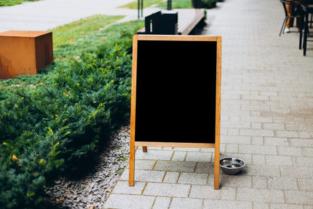 Restaurant sidewalk chalkboard sign board. Old Black Signboard on the city street. Blank store signage sign design mockup isolatedの写真素材