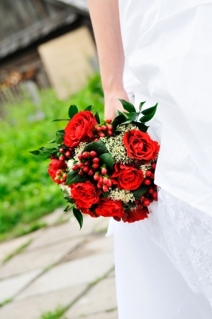 Bride holding beautiful red wedding flowers bouquet の写真素材