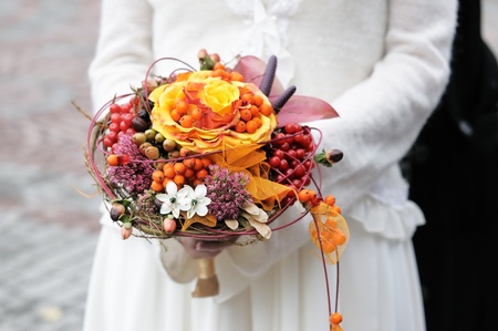 Bride holding beautiful orange wedding flowers bouquet の写真素材