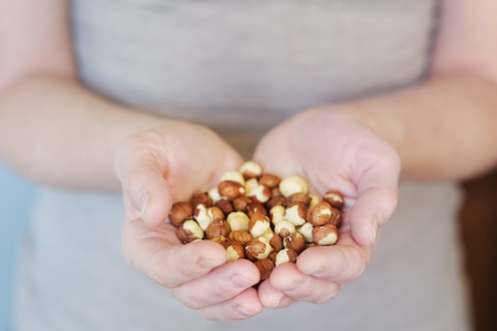 Middle age woman holding hazelnuts in her hands の写真素材