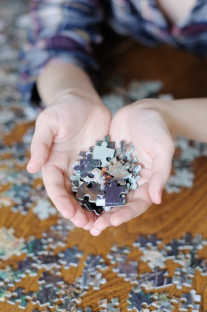 Young woman holding pieces of puzzle in her hands の写真素材
