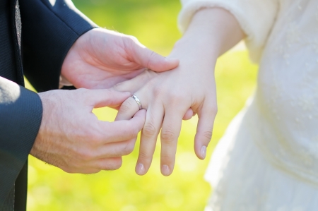 Groom putting a wedding ring on bride s fingerの写真素材