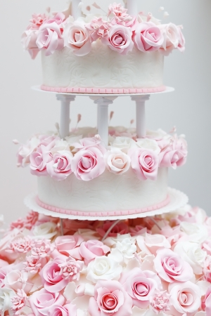 Delicious white wedding cake decorated with pink cream rosesの写真素材