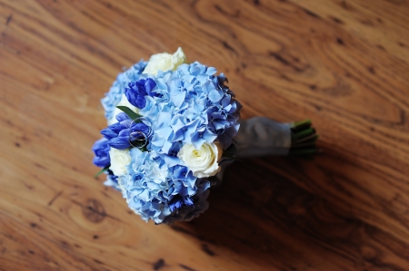 Beautiful wedding flowers bouquet and wedding rings on the wooden dark background, focus on ringsの写真素材