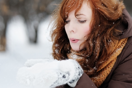 Outdoors portrait of young beautiful woman having fun in winterの写真素材