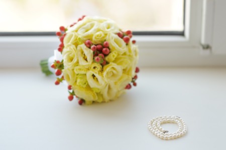 Beautiful pearls and wedding bouquet on window-sillの写真素材