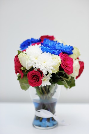 Bright blue and red bouquet on glass vaseの写真素材
