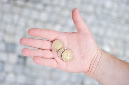 Man holding golden and silvery coins (czech koruna) in his handの写真素材