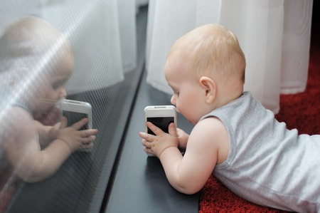 Little baby boy playing with smartphone