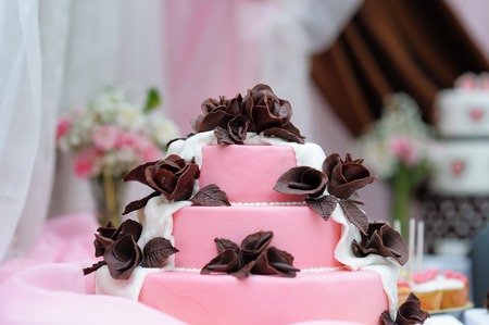 Delicious pink wedding cake decorated with brown cream rosesの写真素材