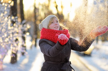 Outdoors portrait of young beautiful woman having fun in winterの写真素材