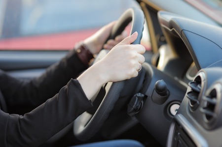Closeup photo of hands of young woman holding steering wheelの写真素材