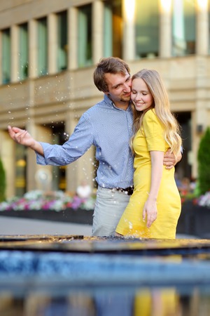 Young couple having fun with a city fountainの写真素材