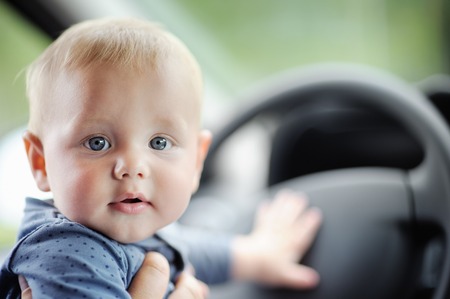 Portrait of sweet baby boy playing in the carの写真素材