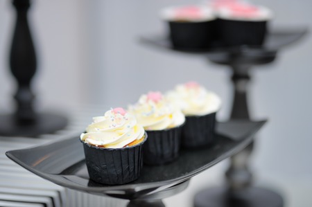 Stylish cupcakes on black glass plateの写真素材