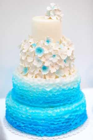 Delicious blue and white wedding cake decorated with cream flowersの写真素材