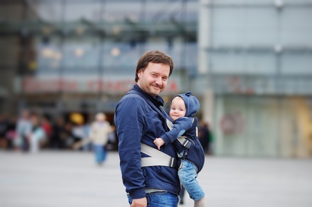 Father and his baby boy in a baby carrier at the big cityの写真素材