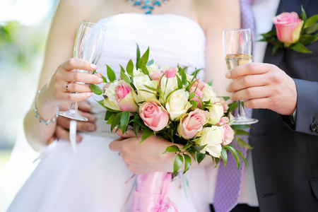 Bride and groom holding champagne glasses, close up photoの写真素材