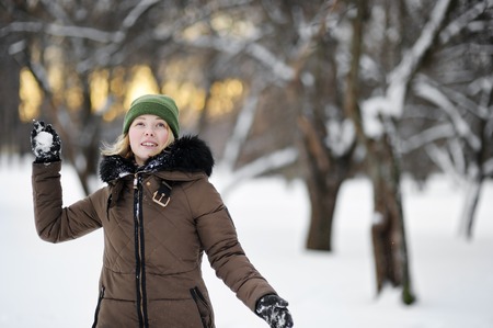 Young beautiful woman having fun in winter park