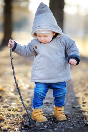 Beautiful toddler boy walking outdoors at the warm spring day