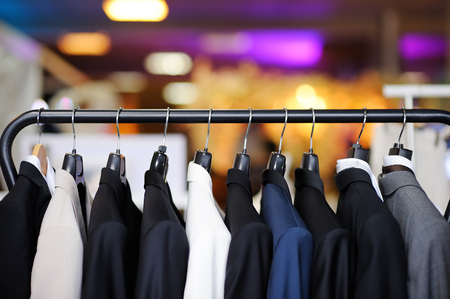 Beautiful suits with tie and handkerchief on a hangerの写真素材