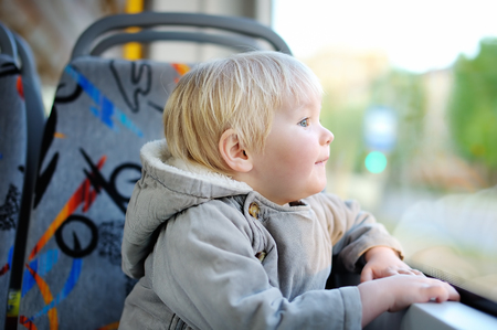 Portrait of cute toddler boy looking out train or tram windowの写真素材