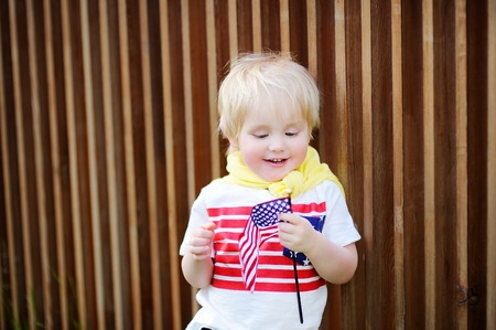 Cute toddler boy holding american flag. Independence Day concept.の写真素材