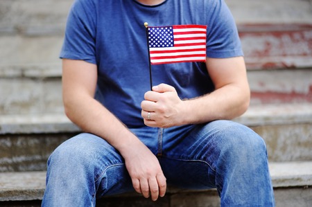Handsome man holding american flag. Independence Day concept.の写真素材