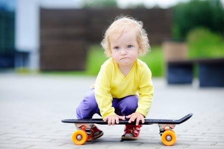 Portrait of cute toddler girl with skateboard outdoorsの写真素材
