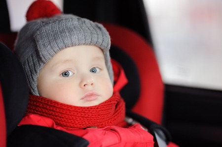 Close up portrait of toddler boy sitting in car seat. Transportation safetyの写真素材