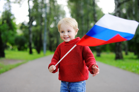 Cute toddler boy holding russian flag outdoorsの写真素材