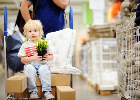 Family with little boy choosing the right furniture for their apartment in a modern home furnishings store. New home for family with kidsの写真素材