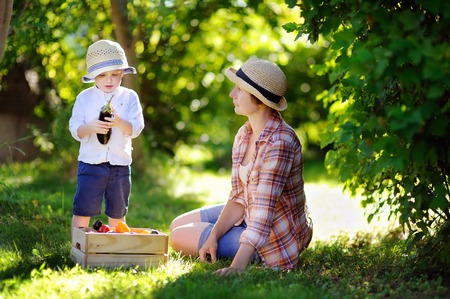 Beautiful middle aged women and her adorable little grandson enjoying harvestの写真素材