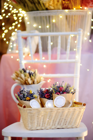 Beautiful dried flowers in paper boxes with lights on background. Wedding decorations close upの写真素材