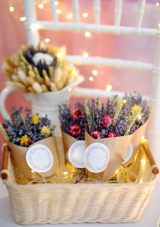 Beautiful dried flowers in paper boxes with lights on background. Wedding decorations close upの写真素材