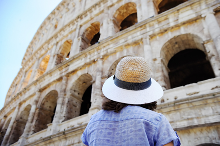 Young female traveler looking on famous the Colosseum in Rome. Sightseeing tour in Italy.の写真素材