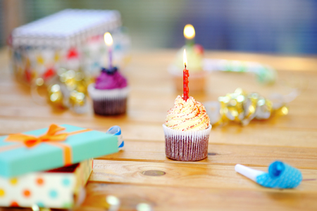 Birthday party with colorful decoration and cakes with candles. Closeup photo with sweets, confetti, candy, whistle/blower/horn and festive gifts.の写真素材
