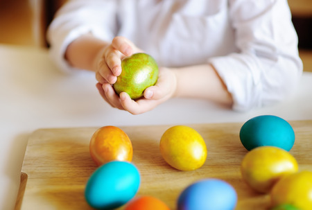 Cute toddler child hunting for easter egg on Easter day. Little boy celebrate Easter at home.