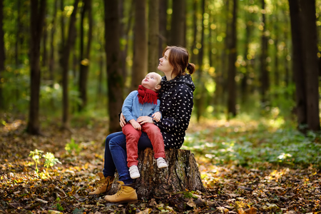 Little boy with his young mother enjoy stroll in the forest. Active family time on nature. Hike with little kidsの写真素材