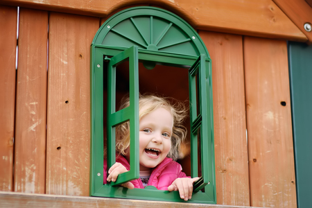Cute little girl having fun on outdoor playground. Spring/summer/autumn active sport leisure for kids. Outdoors wooden equipment for children gameの写真素材