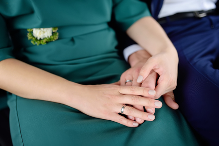 Bride and groom's hands with wedding rings. Newlywed couple holding handsの写真素材