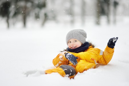 Cute little boy having fun in the snow. Outdoors winter activities for kids.の写真素材