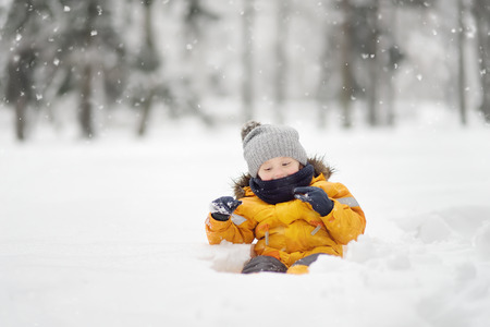 Cute little boy having fun in the snow. Outdoors winter activities for kids.の写真素材