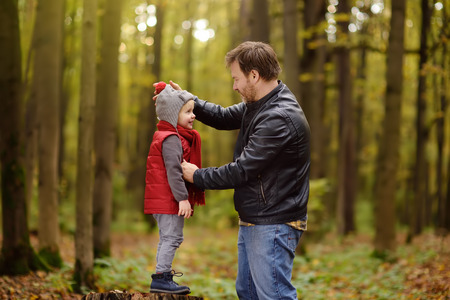 Little boy with his father during stroll in the forest. Active family time on nature. Fun with little kids in fall daysの写真素材
