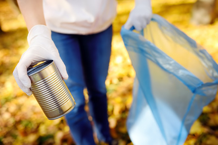 Volunteer picking up the metal garbage and putting it in biodegradable trash-bag on outdoors. Ecology, recycling and protection of nature concept.の写真素材