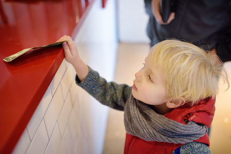 Little boypay off currency note. Kids and money concept. Training in handling money.の写真素材